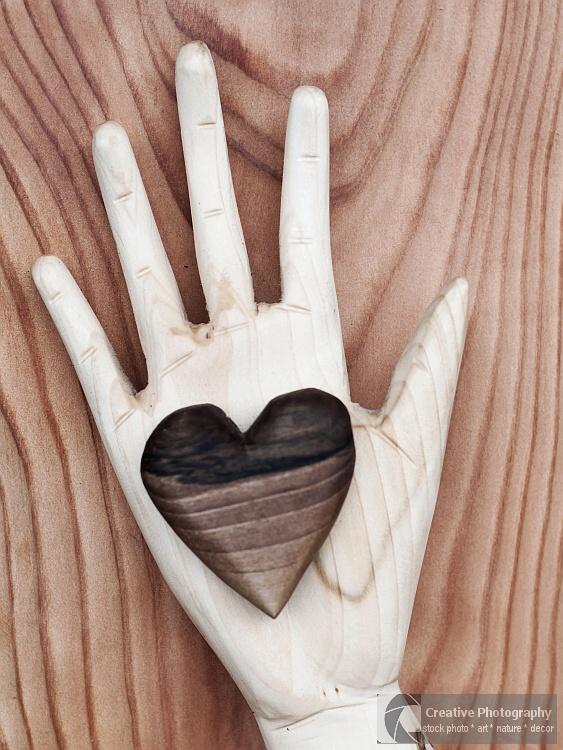 Wooden heart in wooden hand